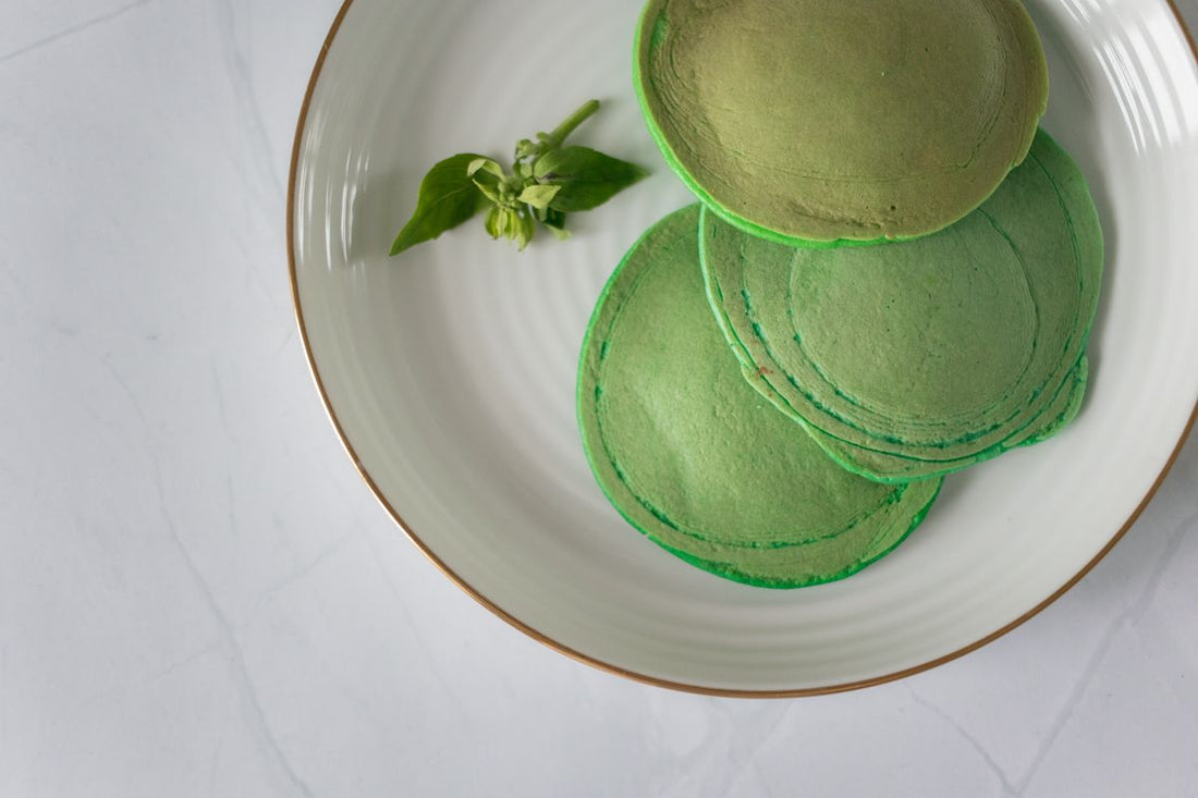 Matcha pancakes recipe with a stack of green pancakes on a white plate
